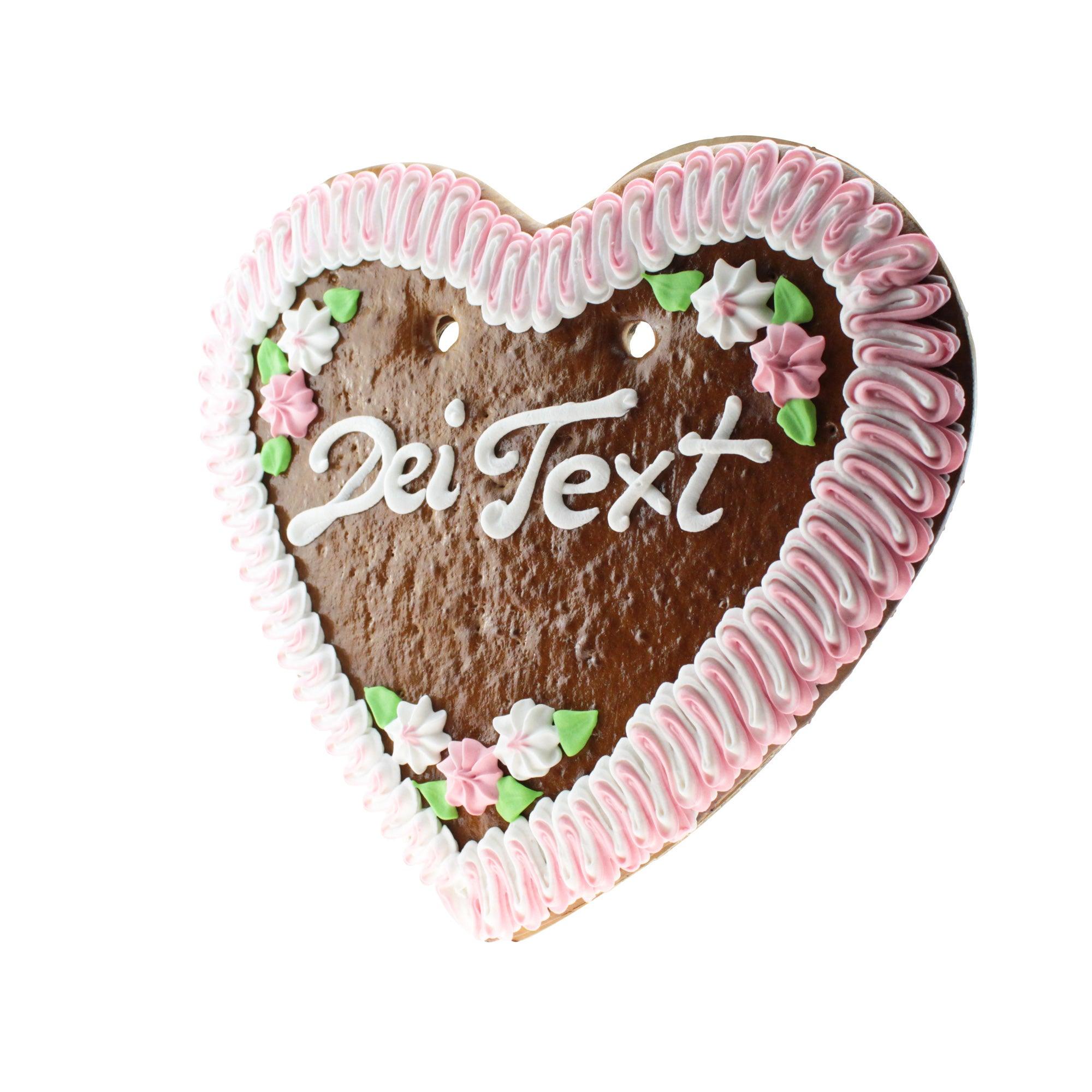Herzförmiges Lebkuchen in Braun mit rosa und weißem Rand, weiß-rosa Schriftzug, handverziert, ca. 36 x 34 cm.