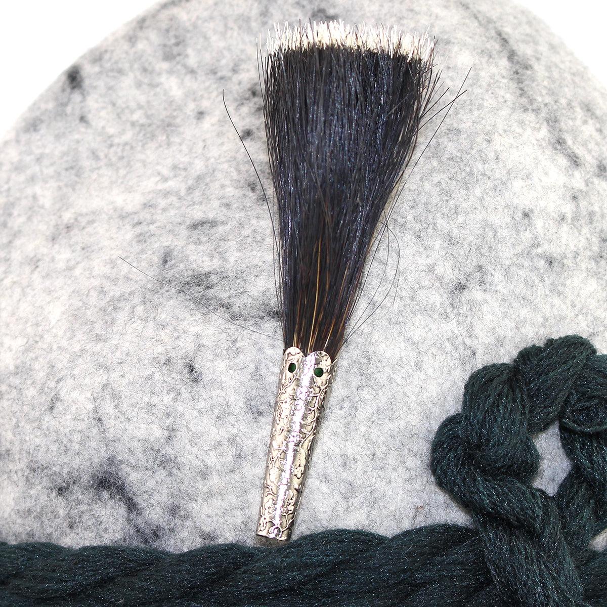 Wiesngamsbart aus braunem Antilopenhaar mit dichter Quaste, Metallhülse und Sicherheitsnadel, ca. 10 cm lang.