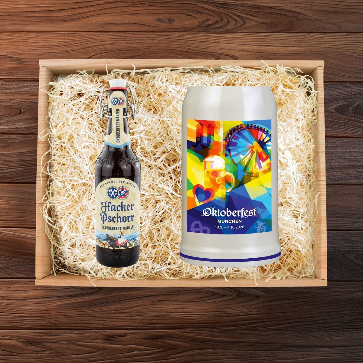 Oktoberfest Geschenkbox mit Hacker Pschorr Märzen Bierflasche und farbigem Wiesnkrug auf Holzwolle.