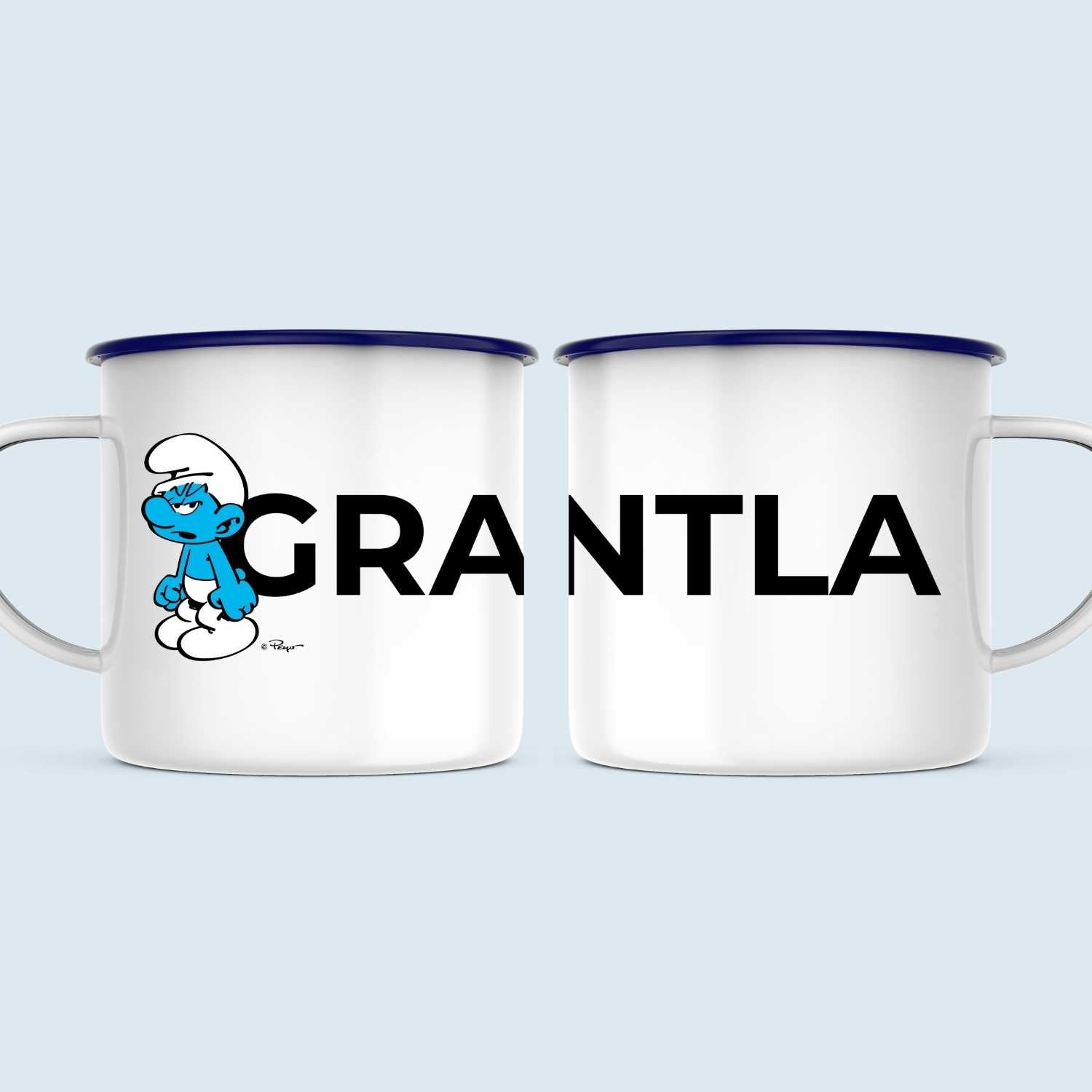 Emailletasse mit Schlumpf-Motiv "Grantla", blauem Rand und weißer Oberfläche, Füllmenge ca. 330 ml.