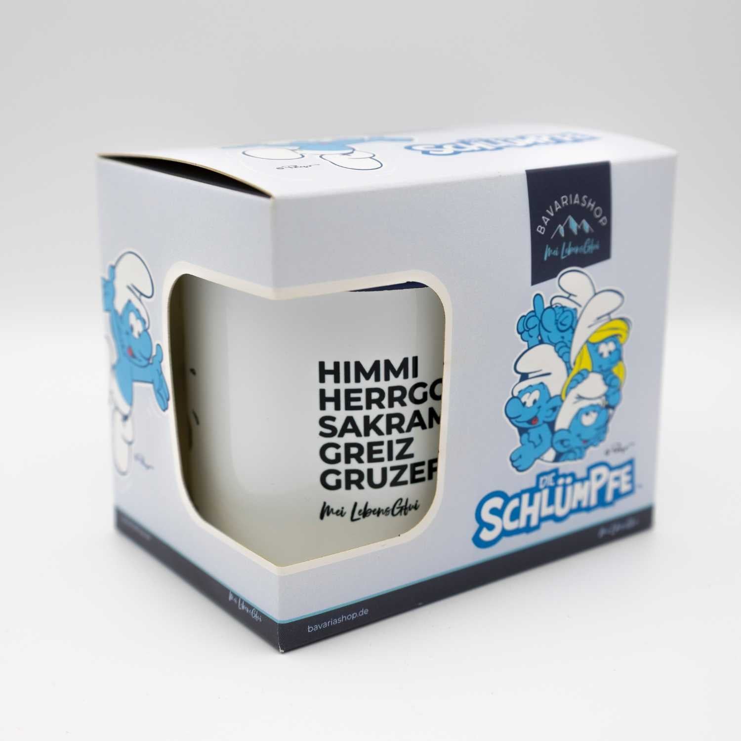 Weiße Emaille-Tasse mit blauem Rand, Schlumpf-Motiv und Schriftzug „Himme Herrgott!“, Füllmenge ca. 330 ml.
