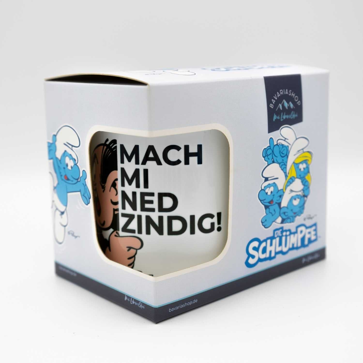 Emailletasse mit blauem Rand, Schriftzug „Mach mi ned zindig“ und Schlumpf-Motiv; Füllmenge ca. 330 ml.