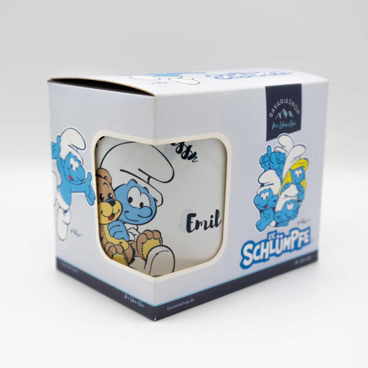 Personalisierbare Emailletasse mit offiziellem Die Schlümpfe-Motiv, blauem Rand und Schriftzug „Mei erste Tassn“, ca. 330 ml.