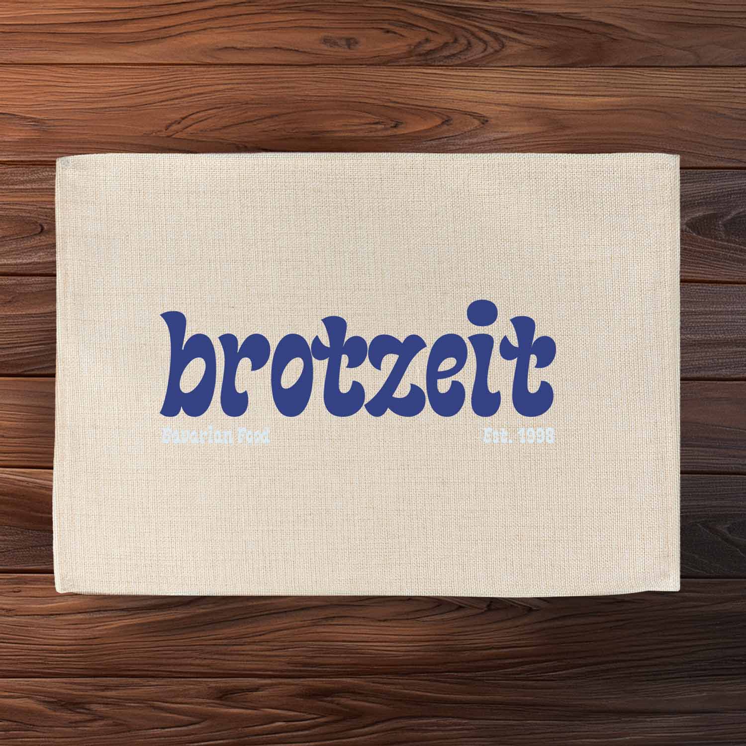 Abwaschbares Tischset in Jute-Optik mit bayerischem Schriftzug „Brotzeit est. 1998“ und rustikalem Druck.