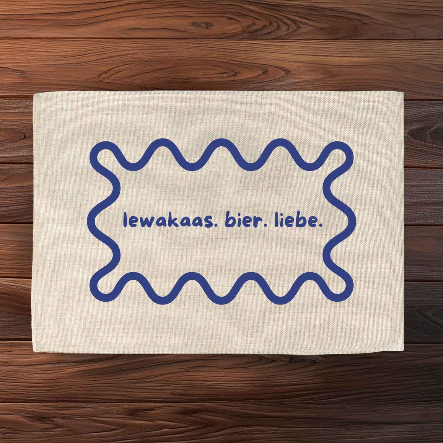 Abwaschbares Tischset in Jute-Optik mit bayerischem Schriftzug „lewakaas. bier. liebe.“ und dezentem Druck.