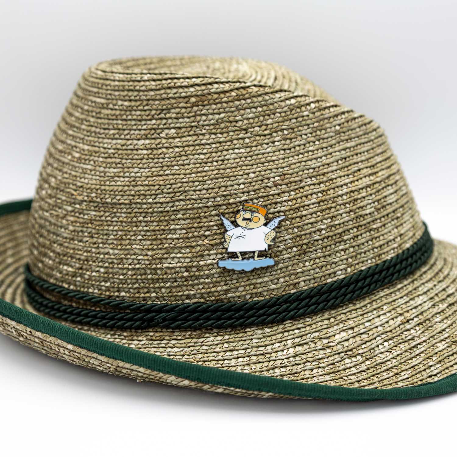 Engel Aloisius Pin Luhja auf einem Strohhut mit grünem Band. Dargestellt ist der Engel mit Heiligenschein.