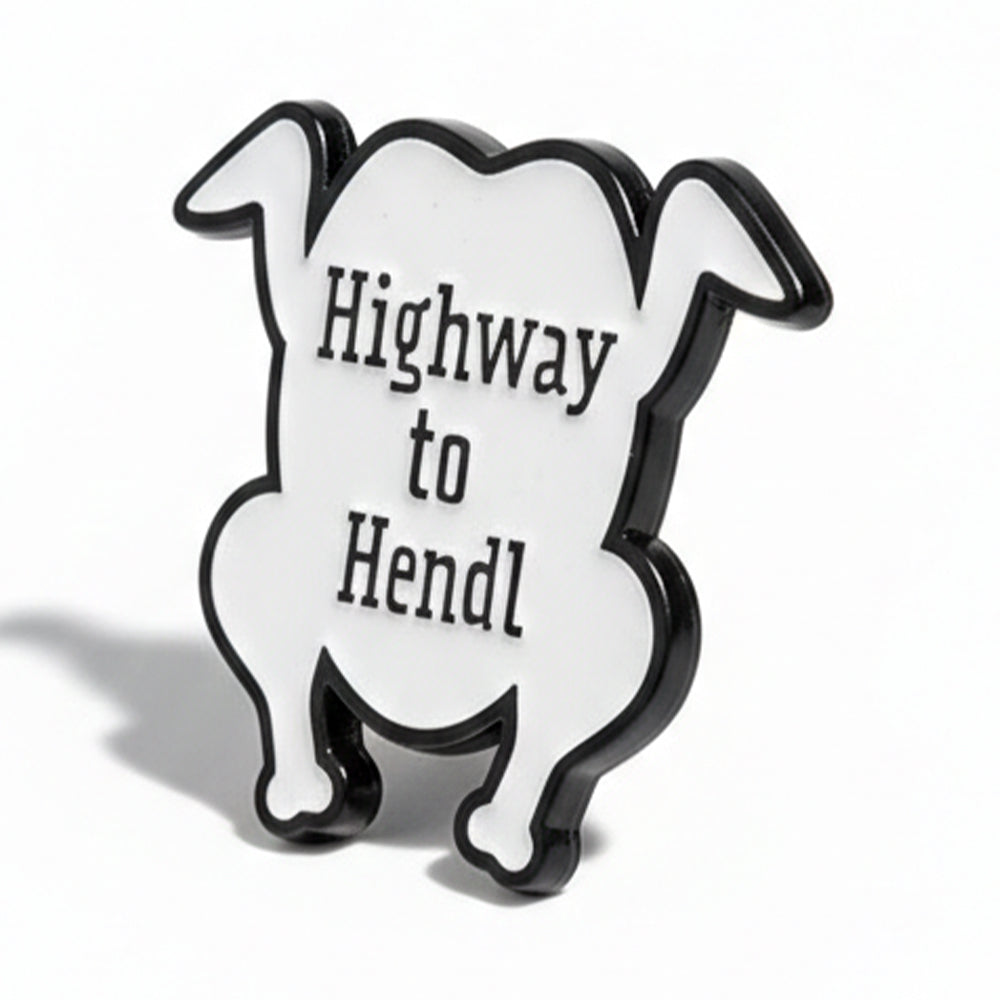 Schwarz-weißer Emaille-Pin in Form eines Hähnchens mit dem Schriftzug "Highway to Hendl". Lustiger Anstecker für Hühner-Liebhaber.