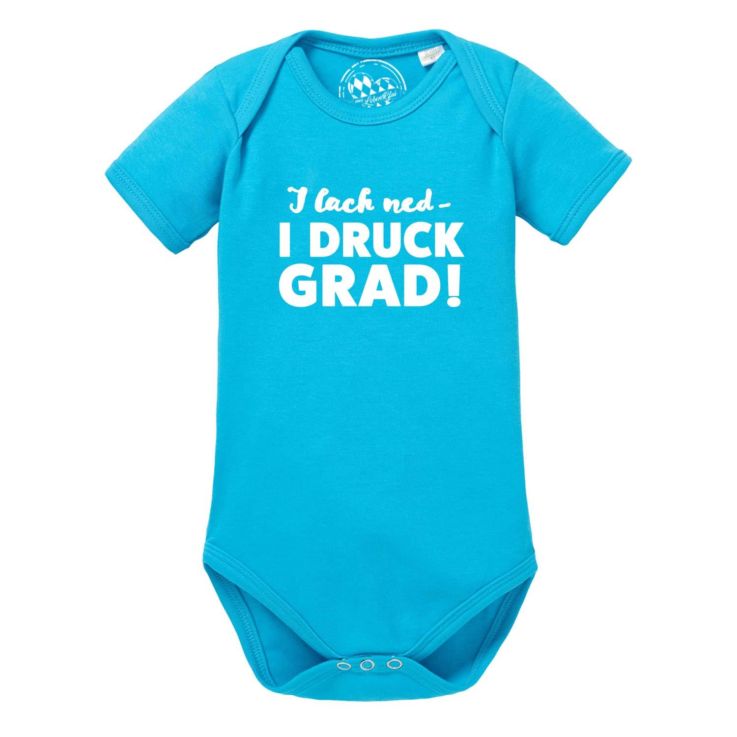 Türkiser Baby Body I lach ned… mit weißem Spruch "I lach ned - I druck grad!" und Druckknöpfen.