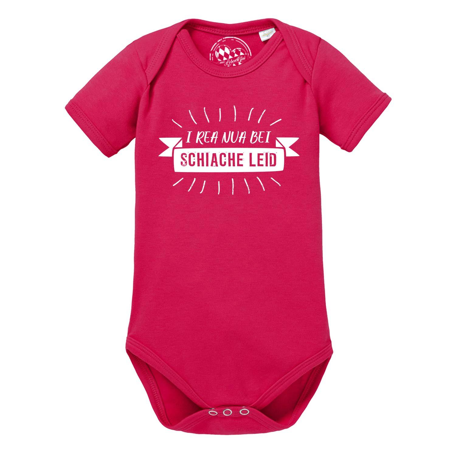 Weißer Babybody mit kurzen Ärmeln und blauem Aufdruck „I rea nua“ in bayerischer Schreibschrift; aus Baumwolle.