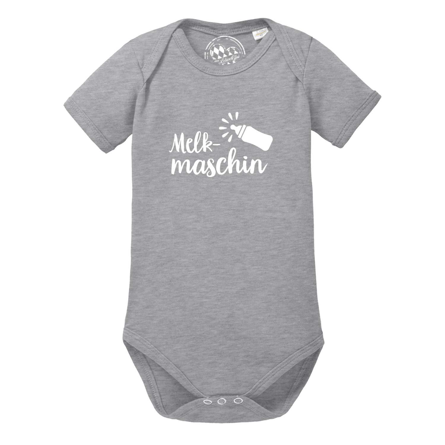 Weißer Baby-Body mit kurzem Arm, blauem Aufdruck „Melkmaschin“ und bayerischem Herzmotiv; aus Baumwolle.