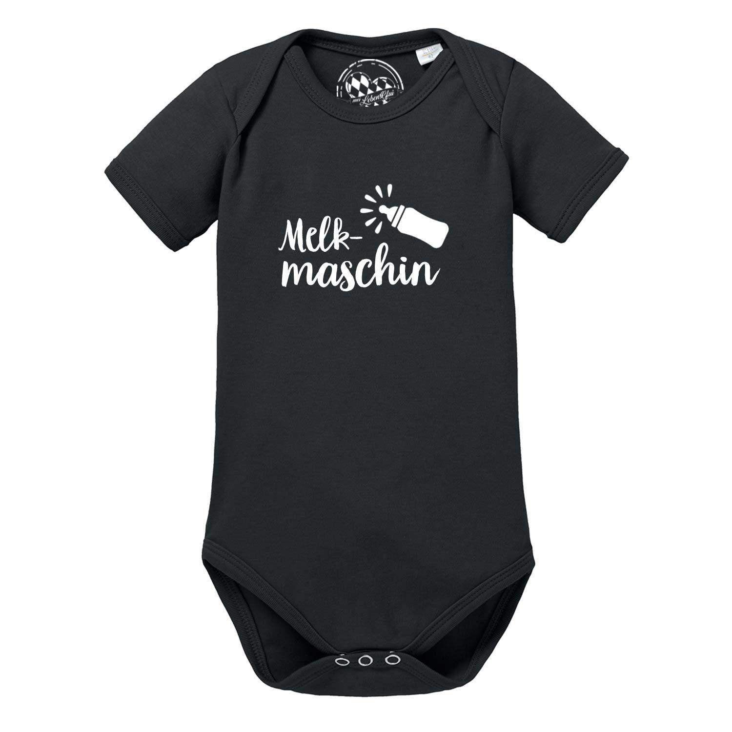 Weißer Babybody mit kurzem Arm, schwarzem Schriftzug „Melkmaschin“ und Herzmotiv auf der Brust; aus Baumwolle.