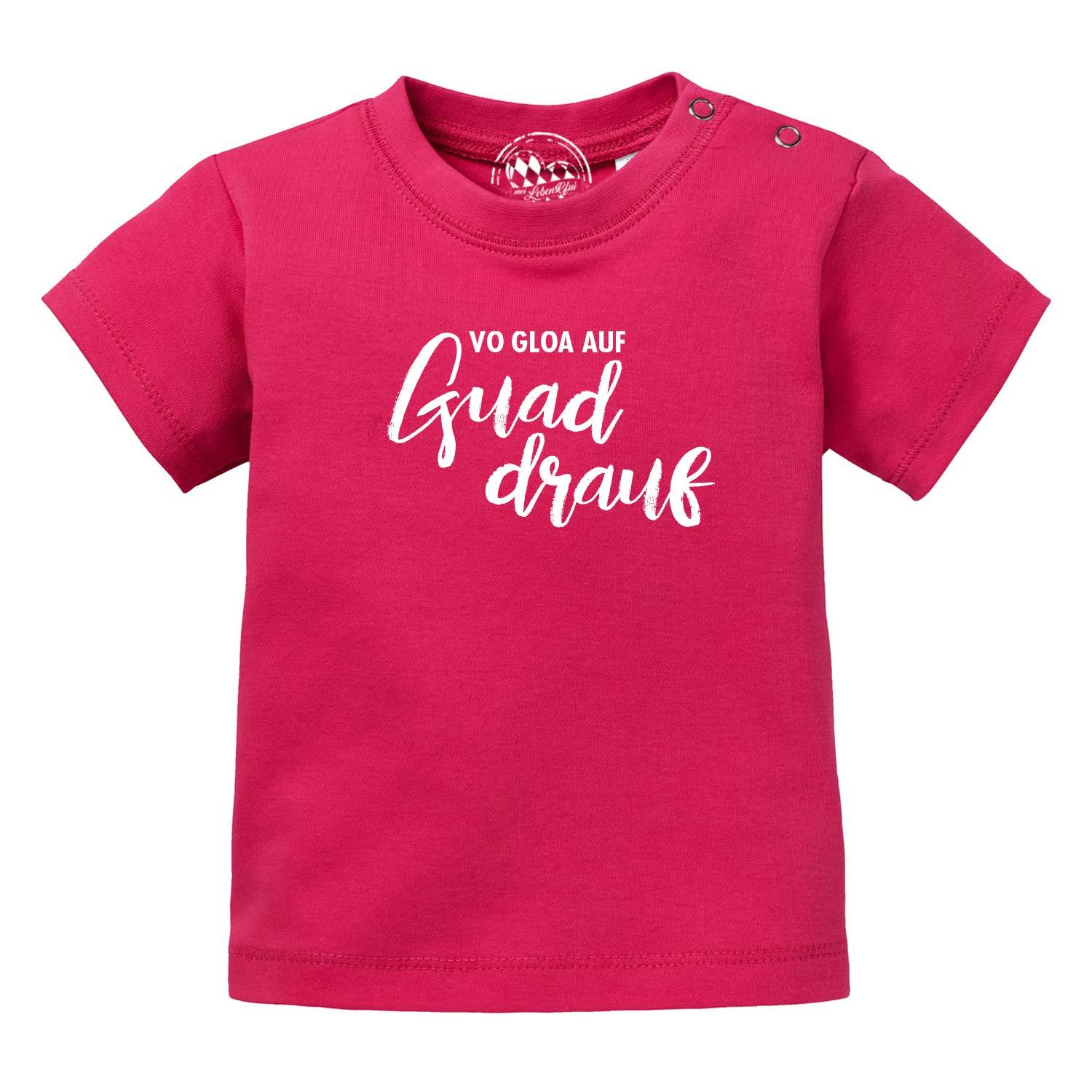 Pinkes Baby T-Shirt "guad drauf" aus Baumwolle mit weißem Schriftzug und Druckknöpfen an der Schulter.
