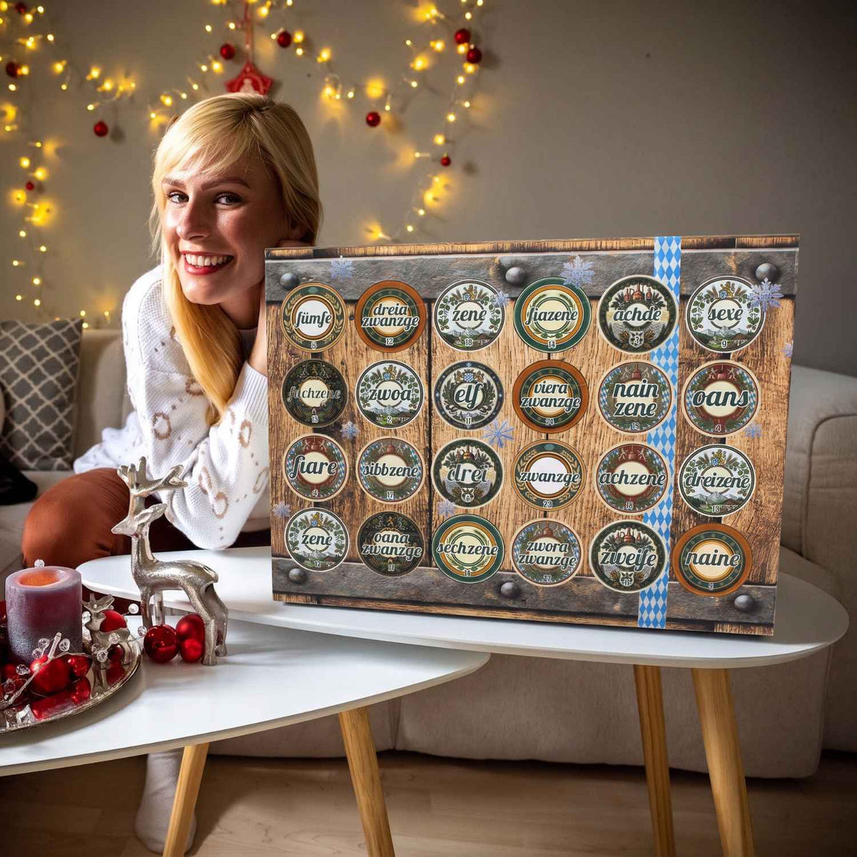 Lächelnde Frau präsentiert Bier Adventskalender in Holzfass-Optik mit bayerischem Muster und Türchen.