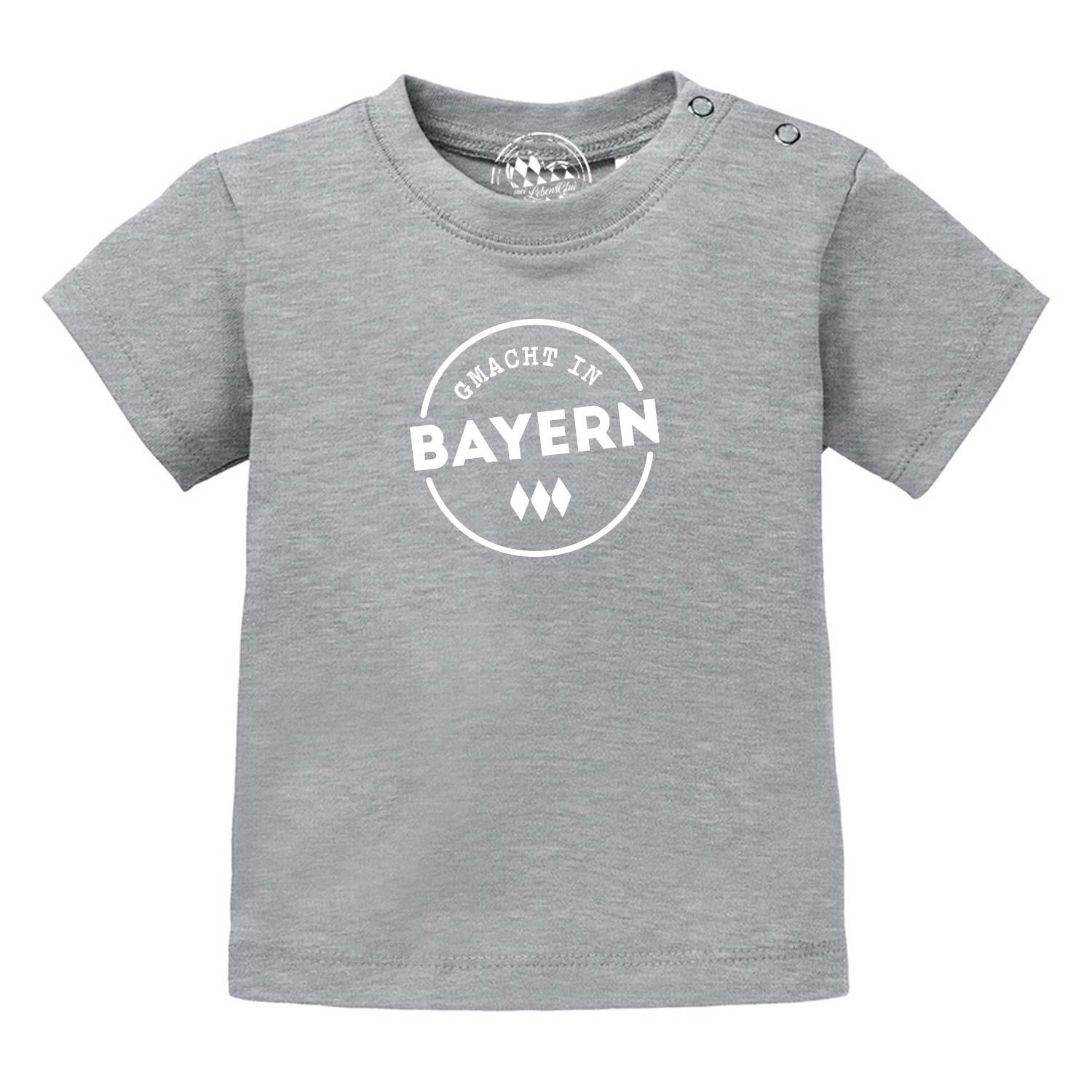 Graues Baby T-Shirt "Gmacht in Bayern" mit weißen Buchstaben und bayerischen Rauten, Druckknöpfe an der Schulter.