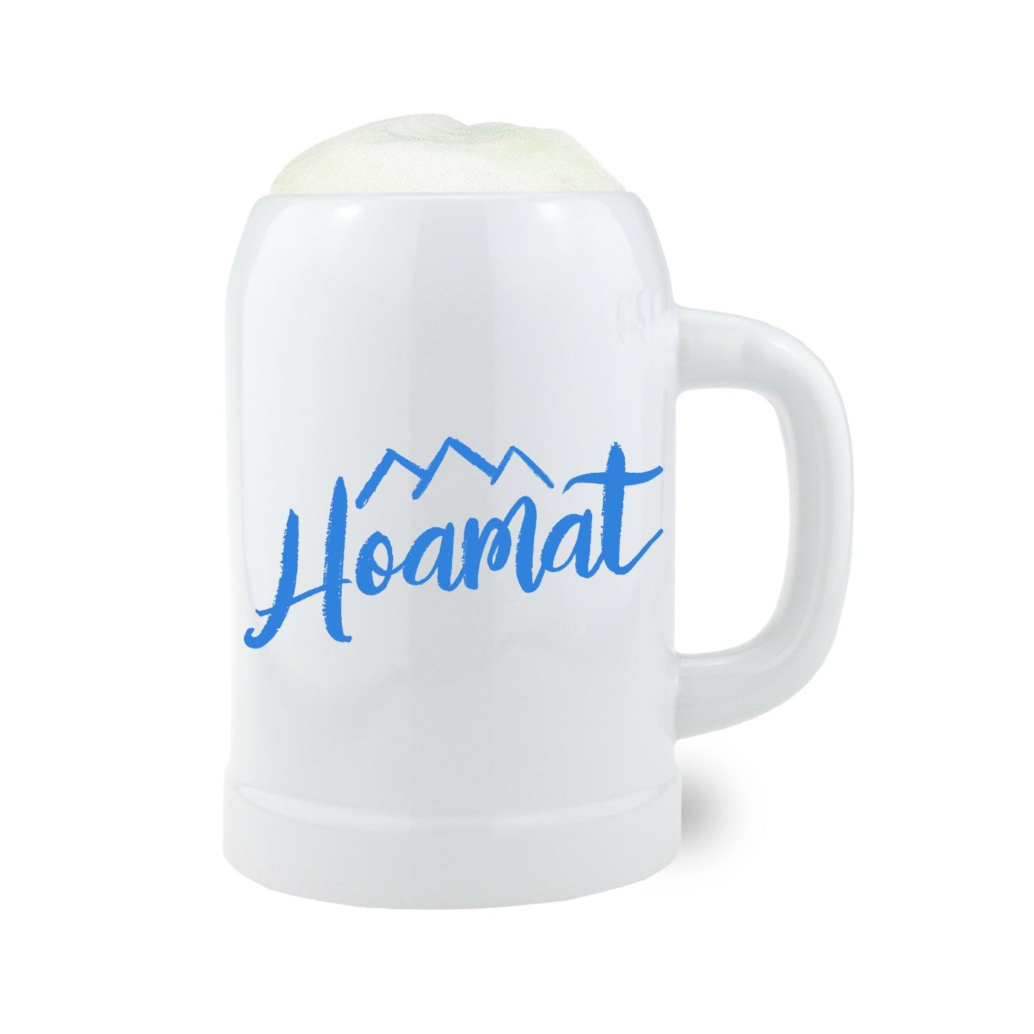 Bierkrug aus Steingut mit traditionellem Schriftzug „Hoamat“ und Bayern-Motiv, zylindrische Form, 0,5 Liter, grau.