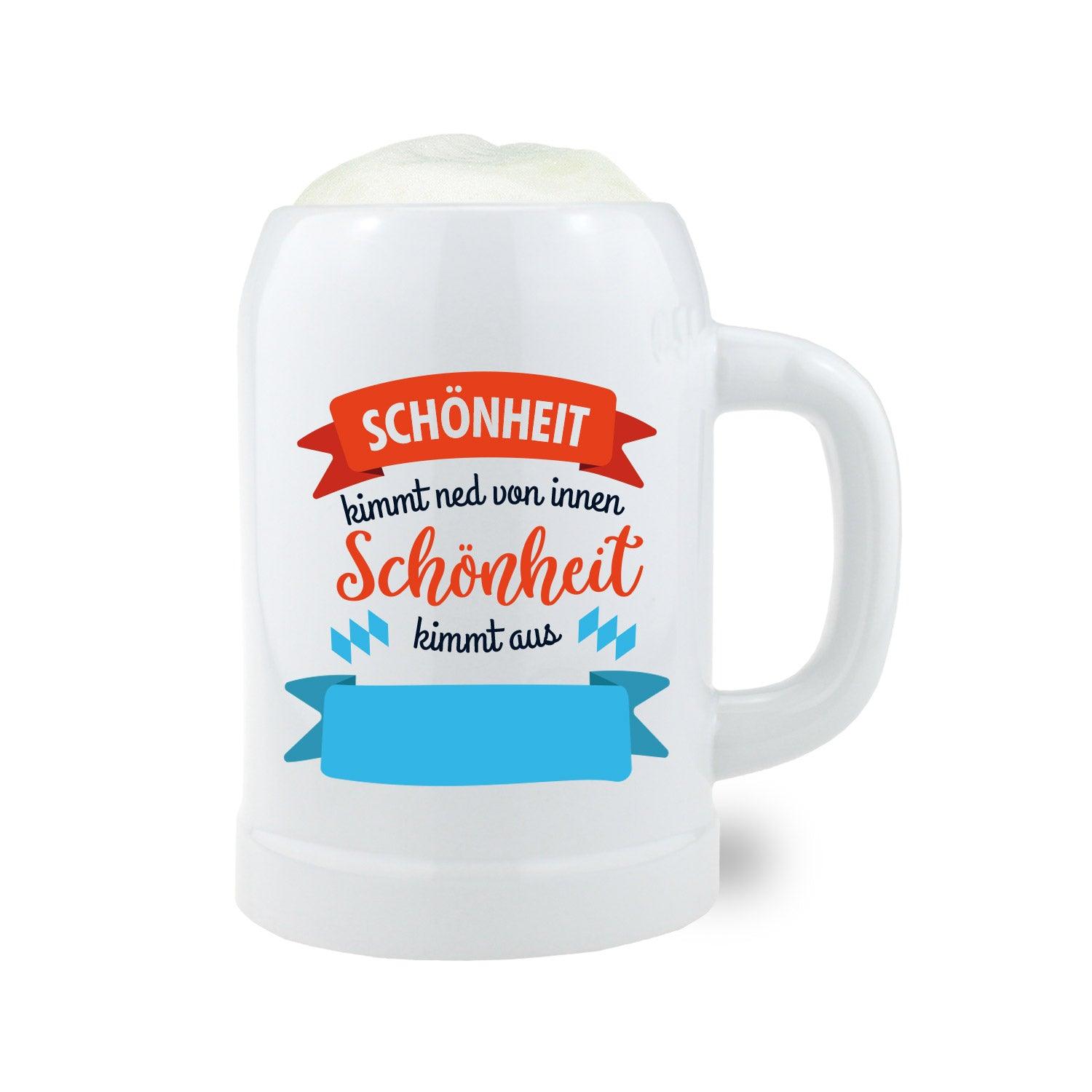 Personalisierbarer Bierkrug aus Keramik mit blauer Beschriftung „Schönheit kimmt aus [Wunschort]“, Fassungsvermögen 0,5 l.