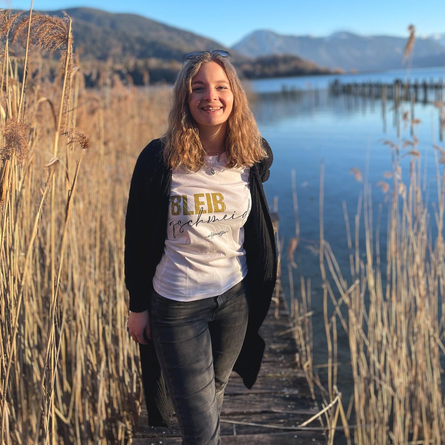 Damen T-Shirt in Weiß mit blauem Schriftzug „Bleib gschmeidig“, Rundhalsausschnitt, 100 % Bio-Baumwolle.
