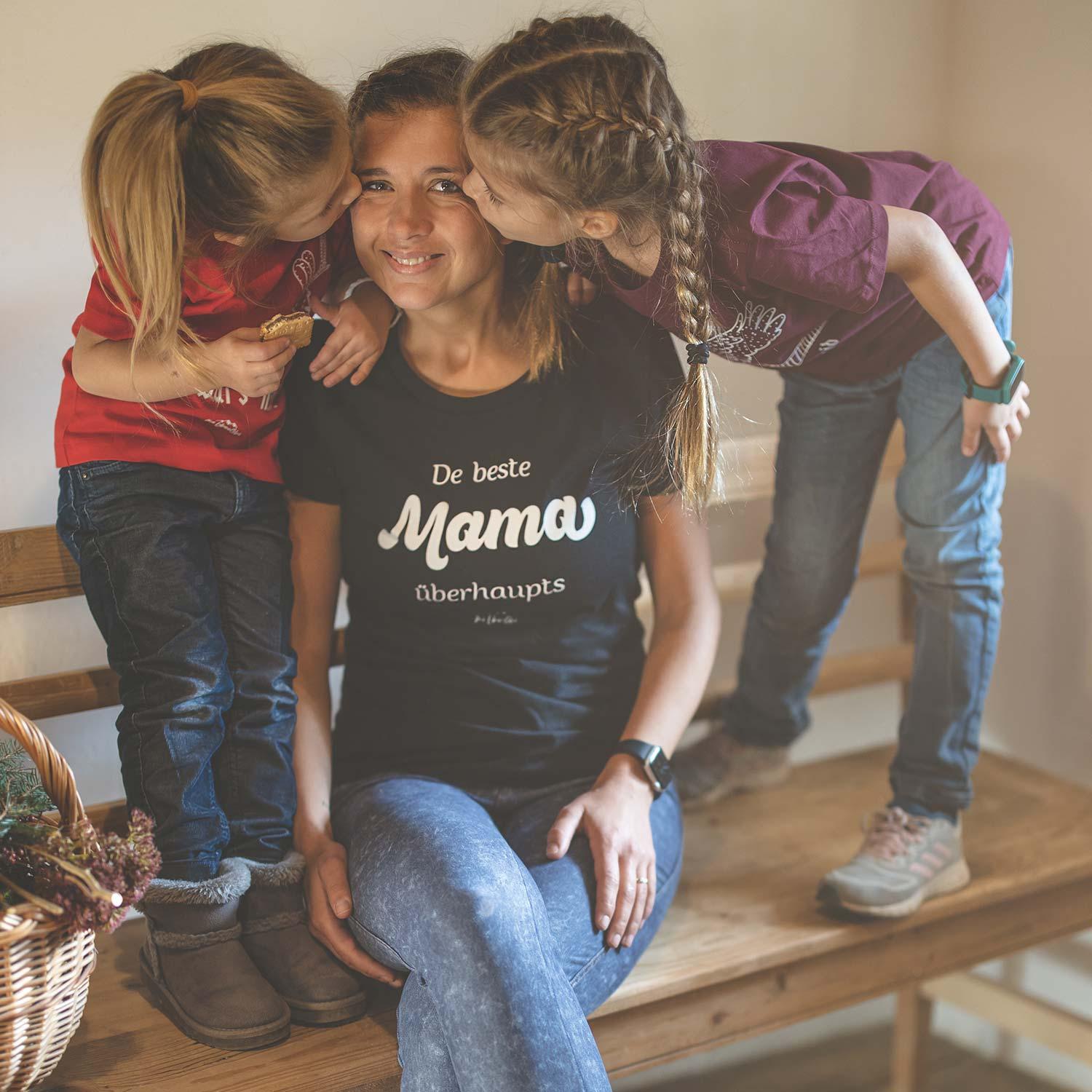 Damen-T-Shirt mit bayerischem Schriftzug „De beste Mama übahaupts“ auf der Vorderseite aus 100 % Bio-Baumwolle.