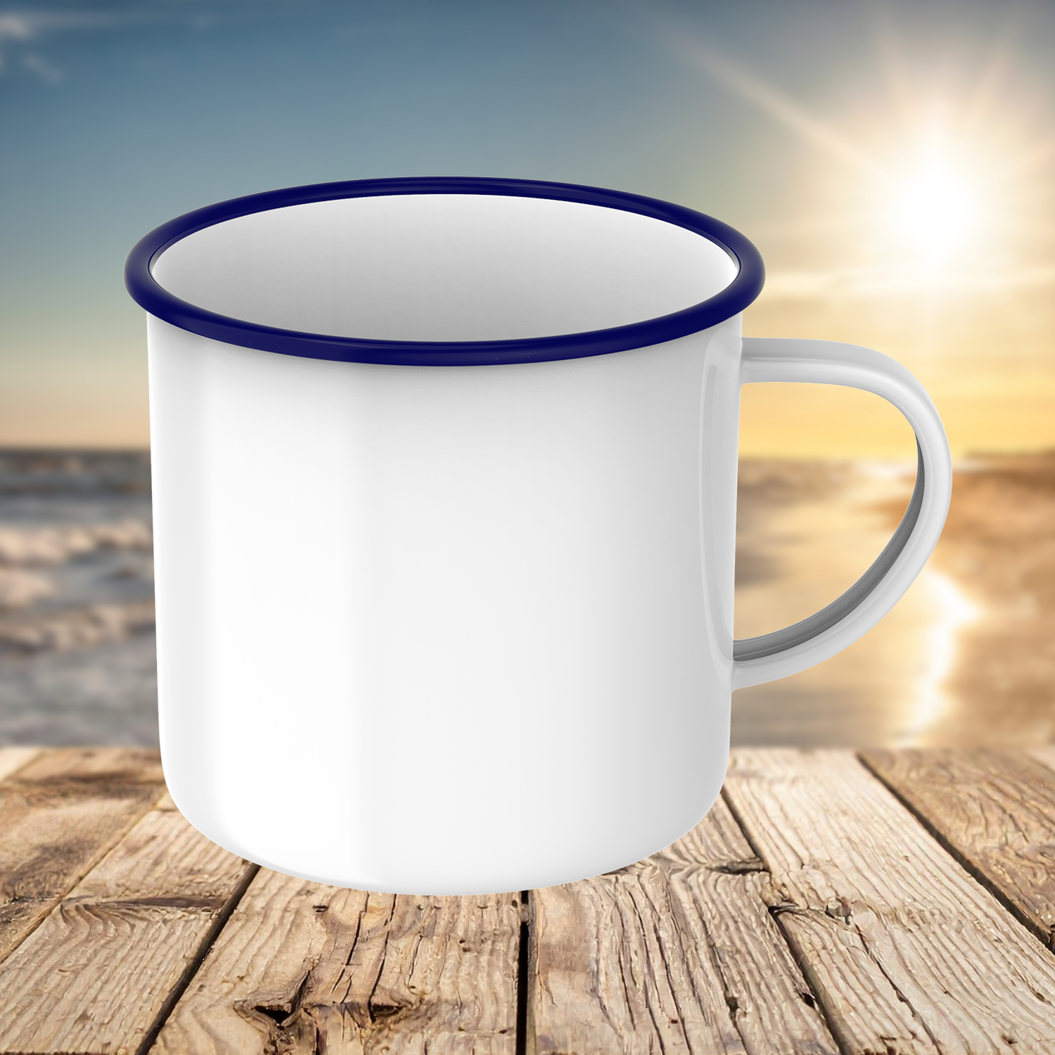 Weiße Emaille-Tasse mit dunkelblauem Rand und Griff auf rustikalem Holztisch vor Strandkulisse.