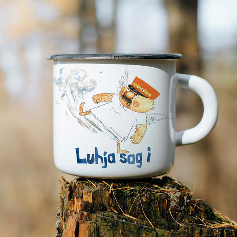 Weiße Engel Aloisius Emaille-Tasse mit buntem Motiv und blauem "Luhja sag i" Schriftzug auf Holzstumpf.