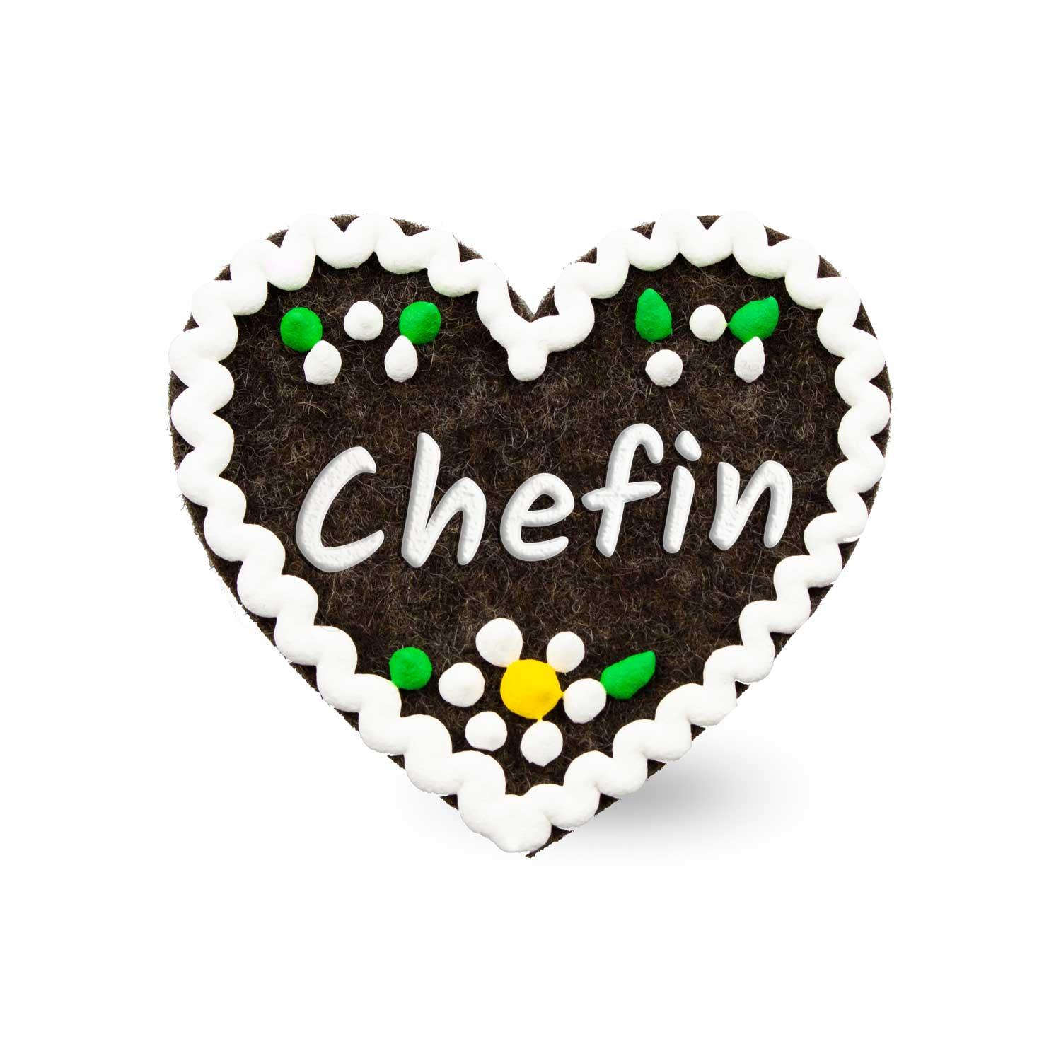 Herzförmiger Filz-Anstecker mit weißem Schriftzug „Chefin“ und dekorativen Stickdetails, ca. 6,5 x 7 cm.