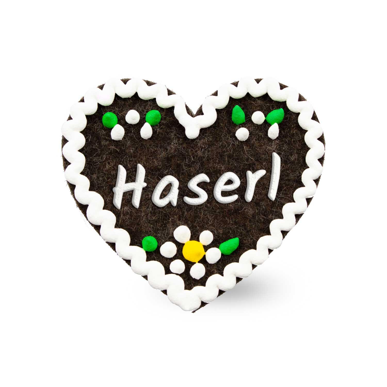 Filzherz-Anstecker mit gesticktem Schriftzug „Haserl“ und Metallverschluss auf der Rückseite, ca. 6,5 x 7 cm.