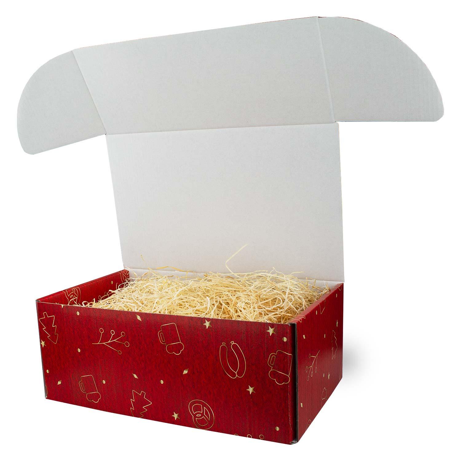 Geöffnete rote Geschenkbox Weihnachtsbox Koids Glüh-Bier gefüllt mit Holzwolle und goldenen Weihnachtsmotiven.