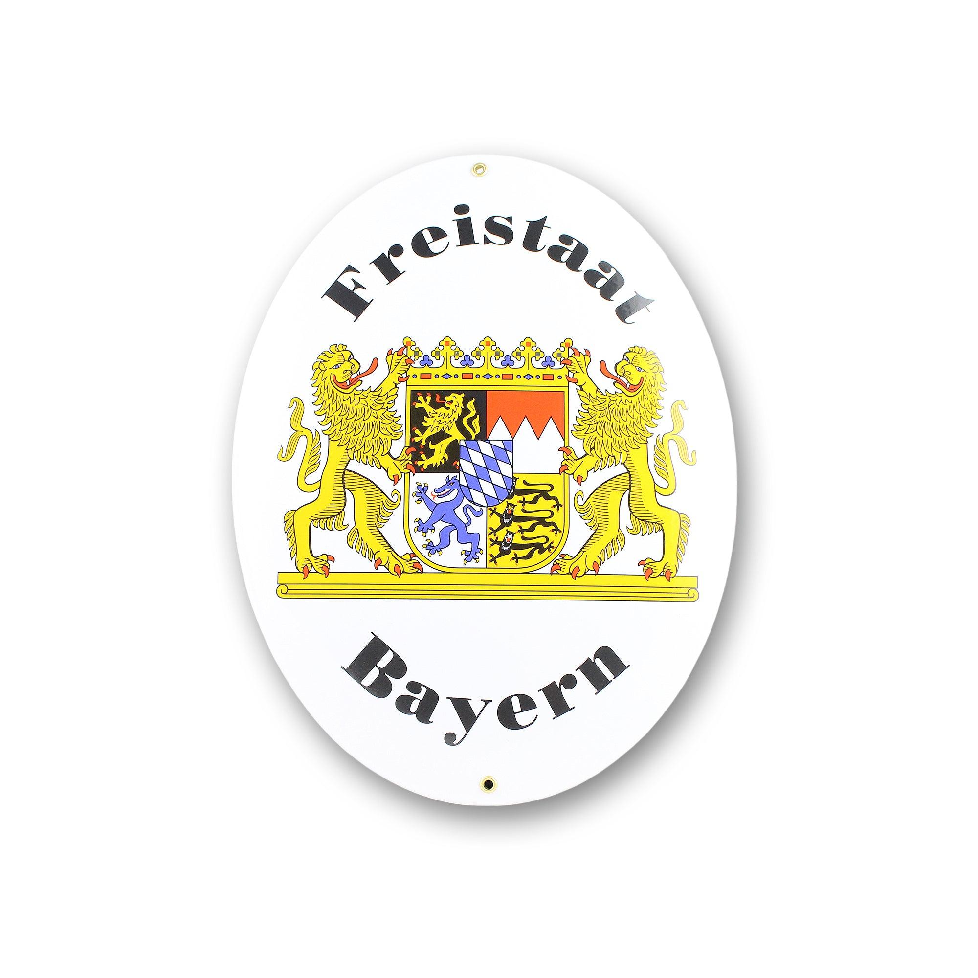 Rechteckiges Metallschild mit bayerischem Staatswappen, blau-weißem Schriftzug „Freistaat Bayern“ und Metallösen, ca. 15 × 11,5 cm.