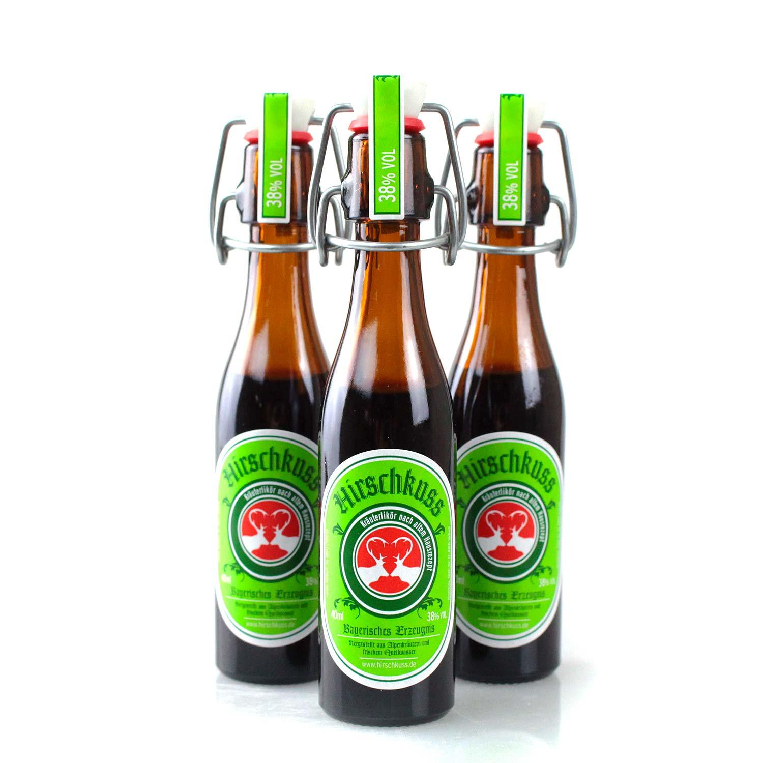 Brauner Kräuterlikör in klarer Glasflasche mit rotem Schraubverschluss und Hirschkuss-Schriftzug, 4 cl, 38 % vol.