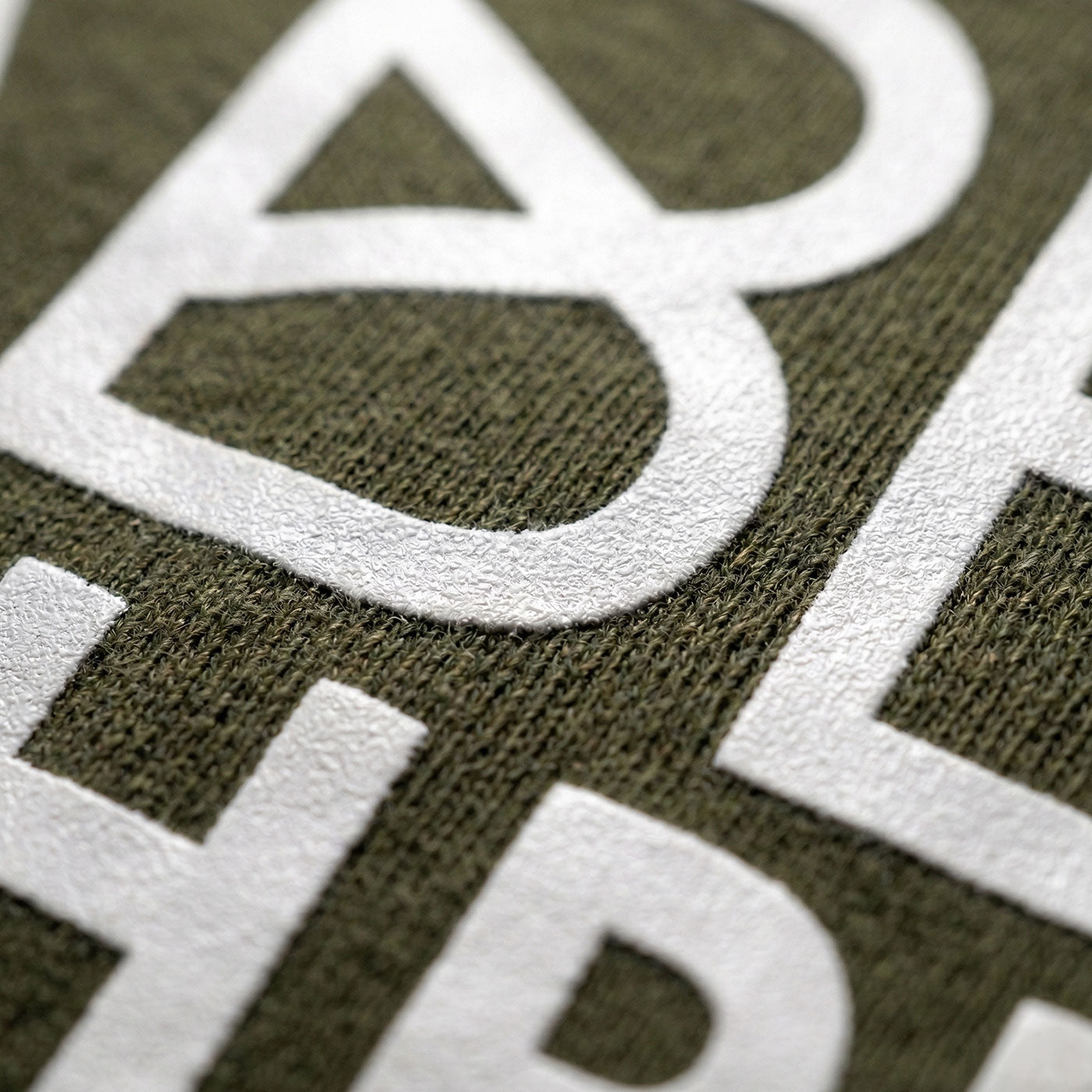Grüner Hoodie mit weißem Flockdruck des Schriftzugs Habe die Ehre Nahaufnahme, Textil-Detail
