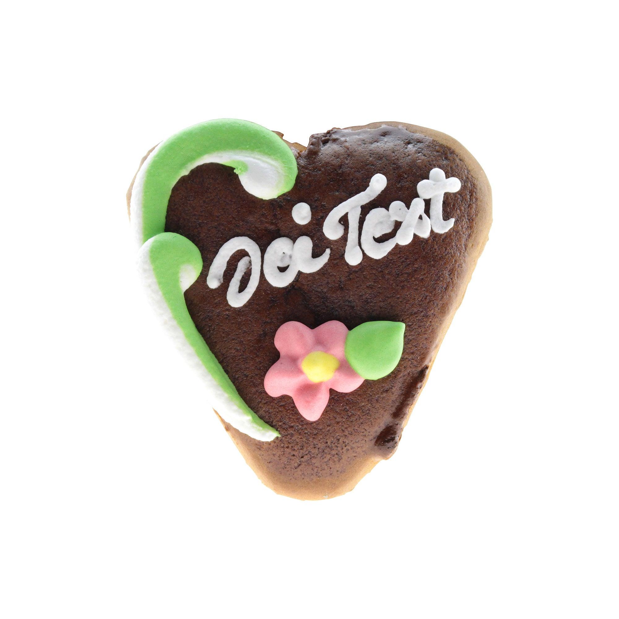 Kleines herzförmiges Lebkuchenherz mit weißem Zuckerrand, brauner Oberfläche und rotem Schriftzug „Anna“, ca. 8 × 7 cm.