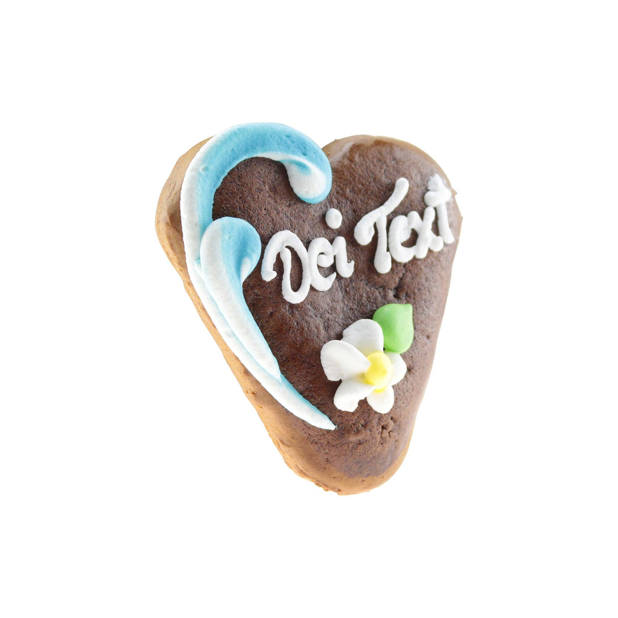 Braunes Mini-Lebkuchenherz mit weißem Zuckergussrand, rosafarbenen Blüten und individuellem Namensschriftzug, ca. 8 × 7 cm.