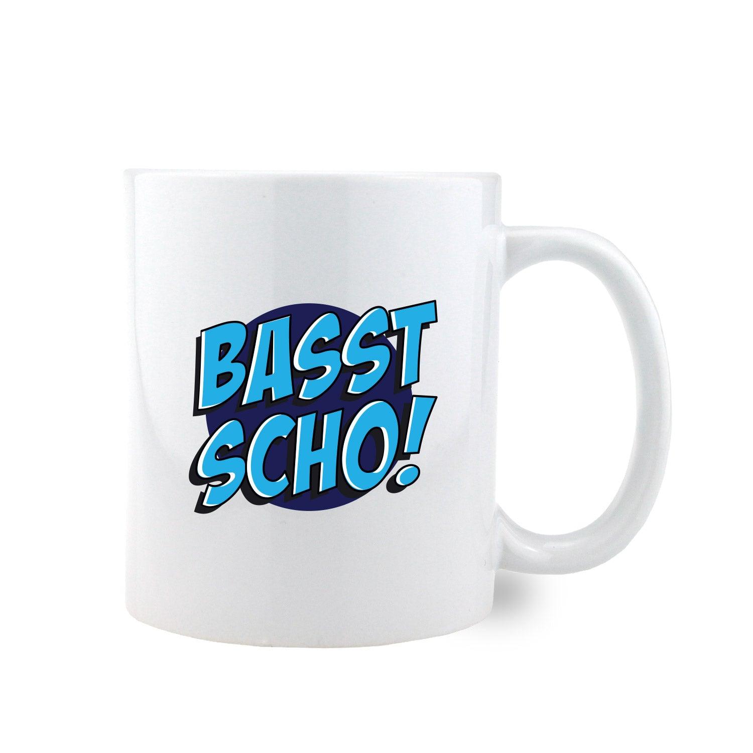 Weiße Keramiktasse mit schwarzem Henkel und schwarzem Aufdruck „Basst scho!” auf der Vorderseite, ca. 330 ml.