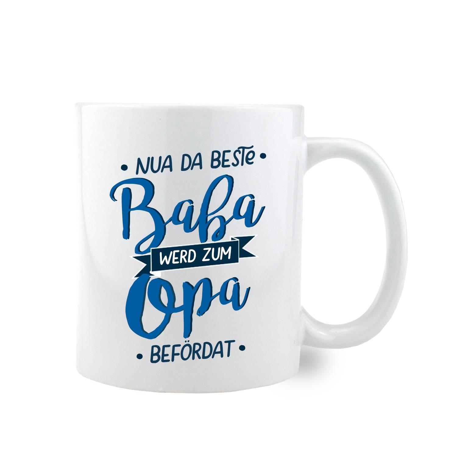 Weiße Keramiktasse mit schwarzem Henkel und schwarzem Innenteil, Aufdruck: „Nua da beste Baba werd zum Opa befördat“, ca. 330 ml.