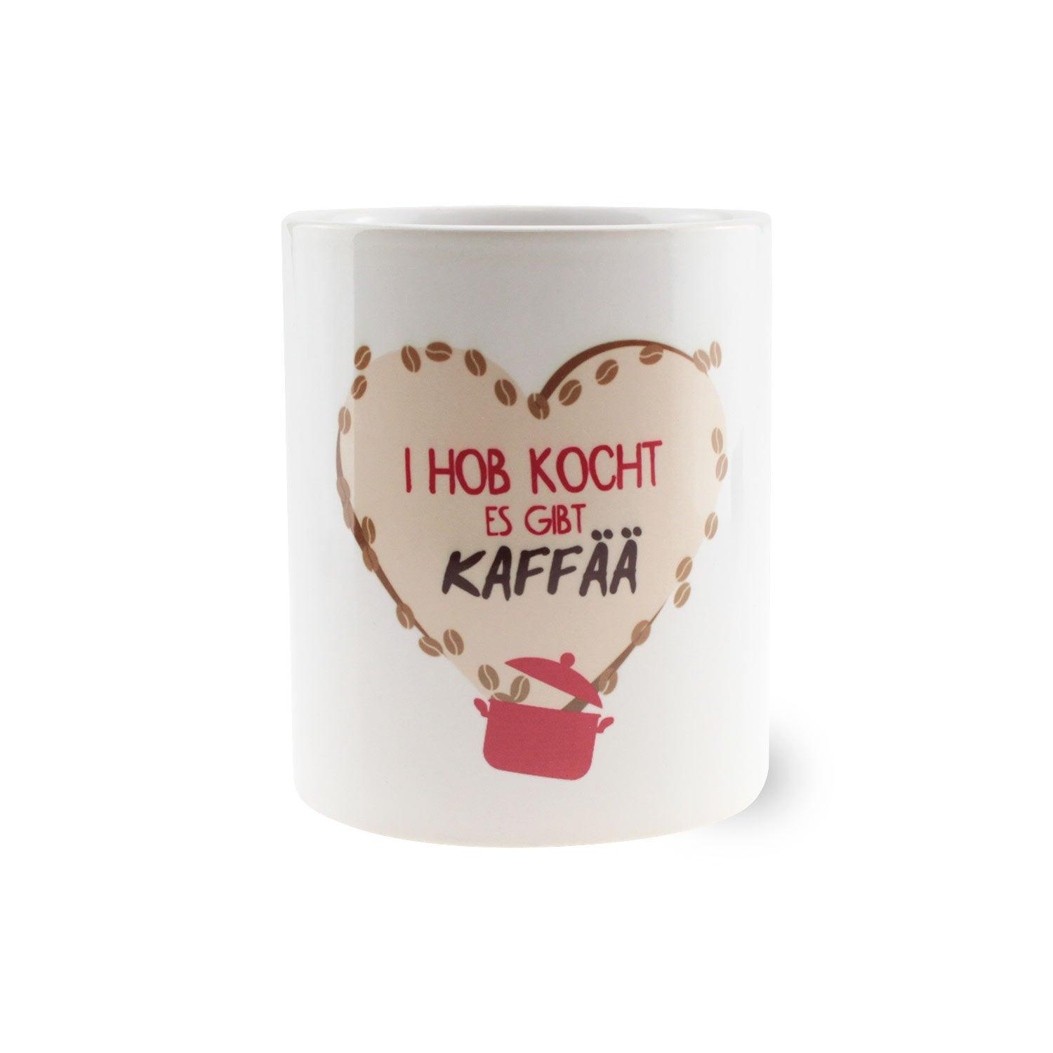 Weiße Keramiktasse mit schwarzem Henkel und Schriftzug „I hob kocht – es gibt Kaffää“, ca. 330 ml, 9,5 cm hoch.
