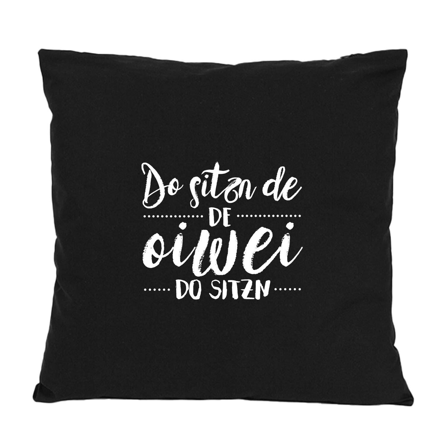 Quadratisches Dekokissen mit aufgedrucktem bayerischem Schriftzug „Do sitzn de…“, aus 100 % Baumwolle, ca. 40 × 40 cm.