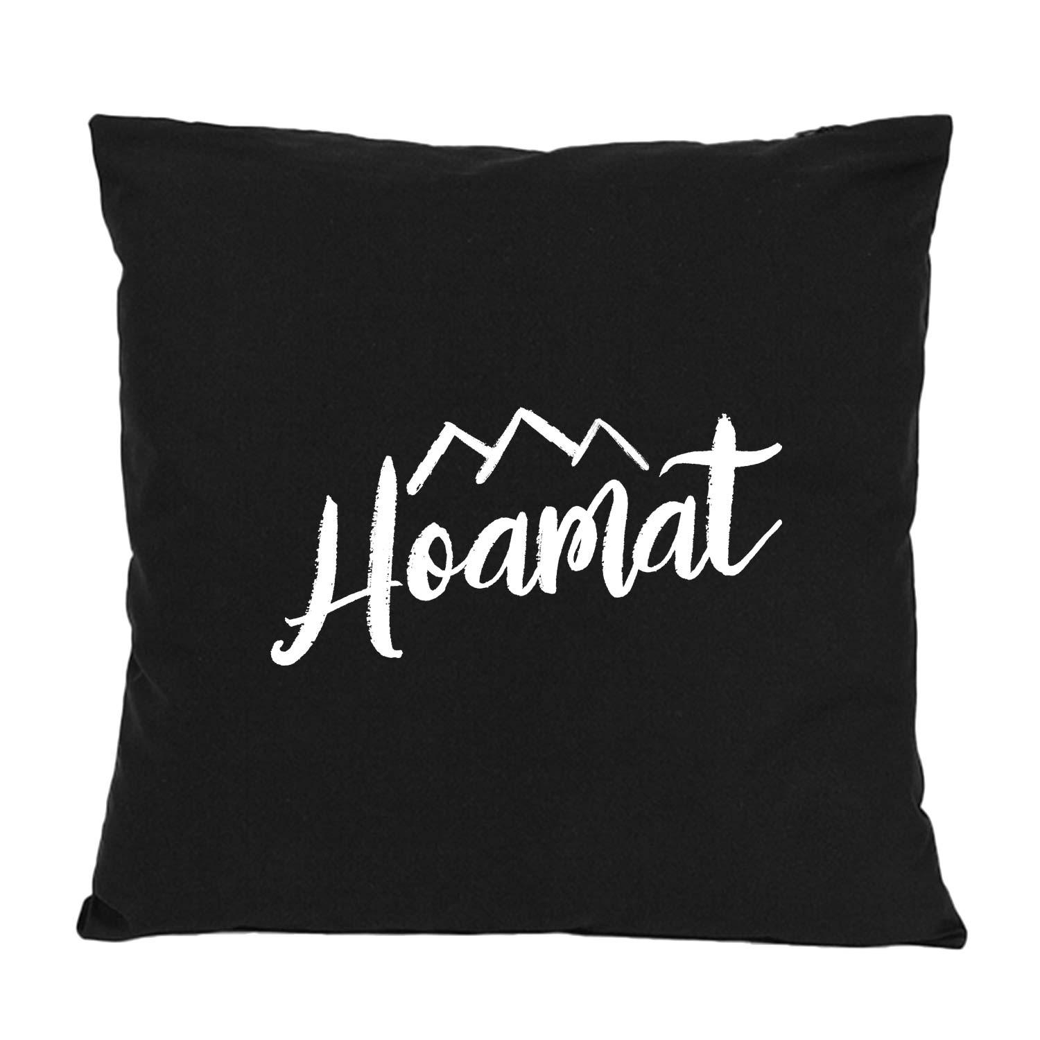 Dekokissen mit sichtbarem Schriftzug „Hoamat“ in Herzform, quadratisch, aus 100 % Baumwolle, ca. 40 × 40 cm.