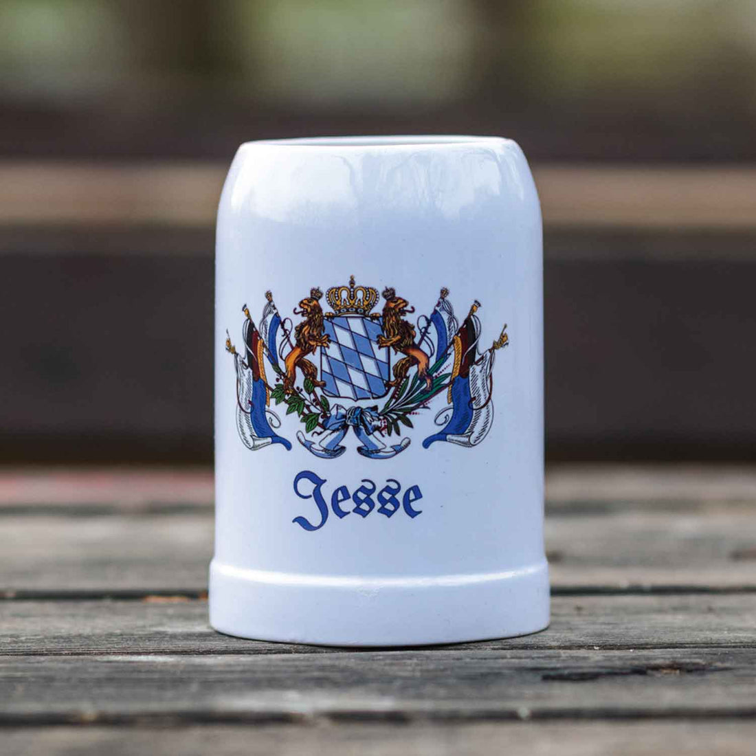 Weißer Keramik-Bierkrug mit bayerischem Wappen und personalisiertem Aufdruck "Jesse" auf Holzoberfläche platziert