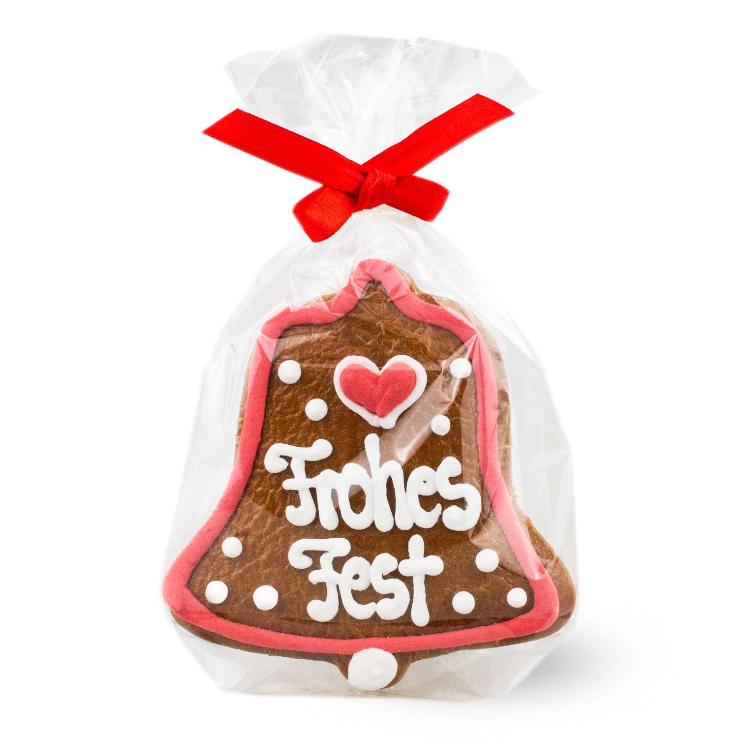 Lebkuchen-Glocke mit weißer Zuckerschrift „Frohes Fest“ und roter Schleife, aus braunem Pfefferkuchenteig.