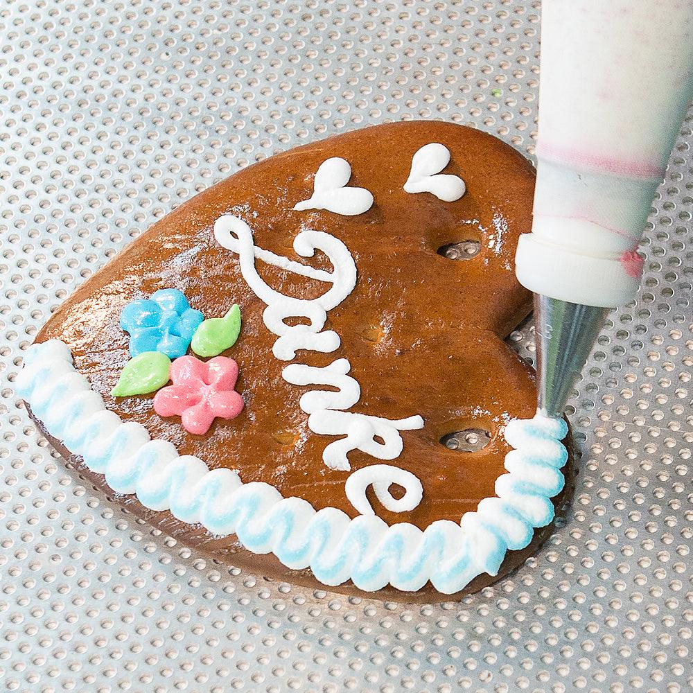 Herzförmiges Lebkuchenherz mit blau-weißer Zuckerdekoration und Schriftzug „Gratulation Bua“, handgefertigt, ca. 14 × 17 cm.