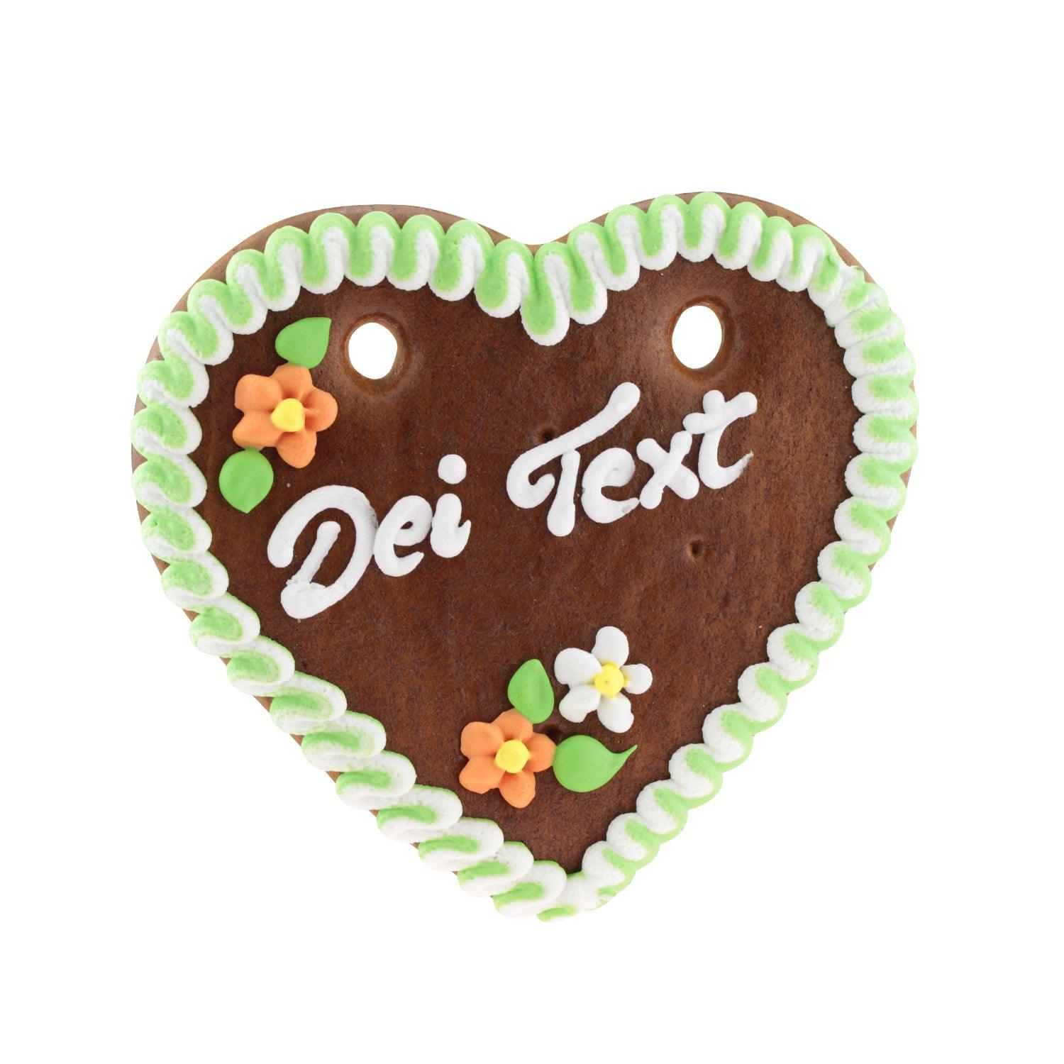 Braunes Lebkuchenherz mit weißer und rosa Zuckerverzierung, personalisierbarem Schriftzug, Herzform, ca. 14 × 17 cm, 100 g.