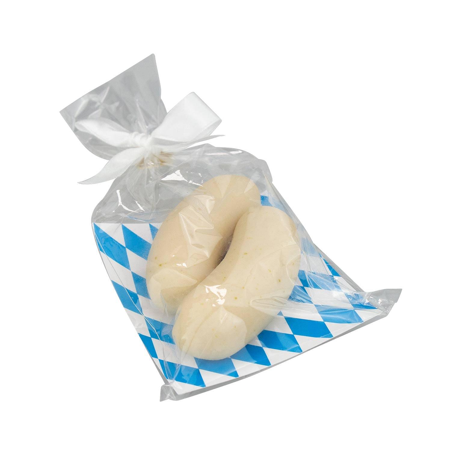 Oktoberfest-Box Maßkrug-Tasse mit zwei weißwurstartigen Süßigkeiten in transparenter Tüte, auf bayerischem Rautenmuster.