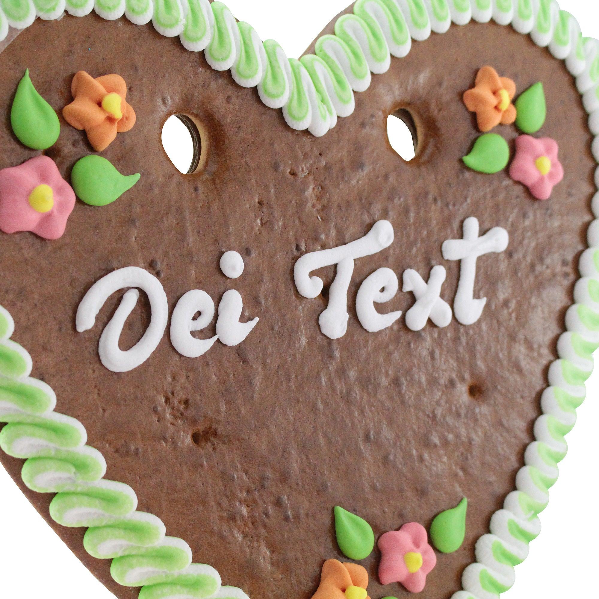 Braunes Lebkuchenherz in Herzform mit rot-weißer Zuckergussumrandung, weißem Schriftzug und Zuckerdekoren, ca. 32×28 cm.