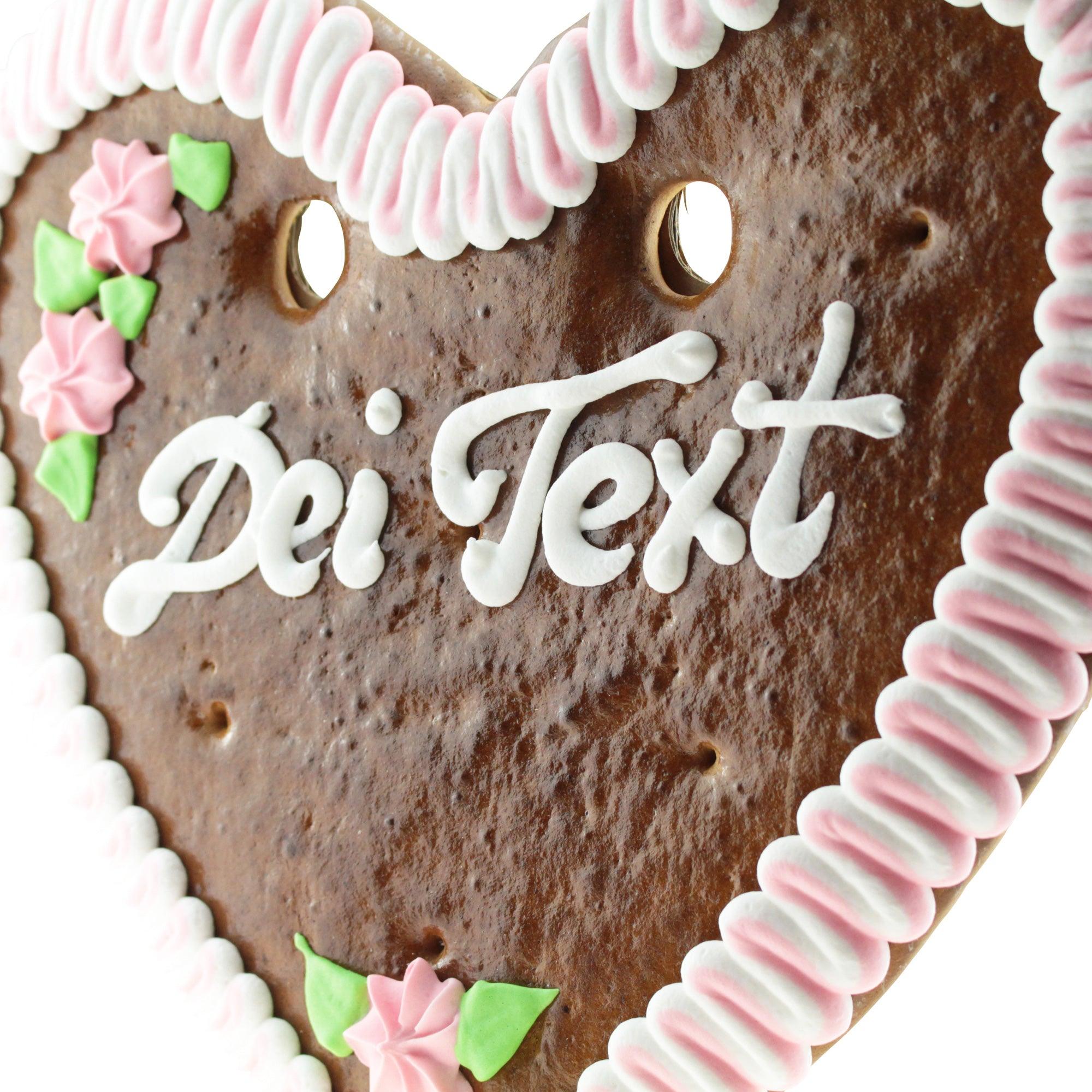Herzförmiges Lebkuchenherz aus braunem Teig mit weiß-blauer Zuckerverzierung und personalisierbarem Schriftzug, ca. 32 × 28 cm.