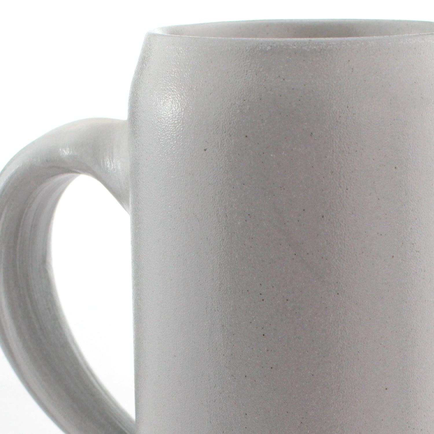 Salzglasierter Steinkrug in Naturgrau mit bauchiger Form, Prägung eines Emblems und gravierbarem Logo, 0,5 Liter.
