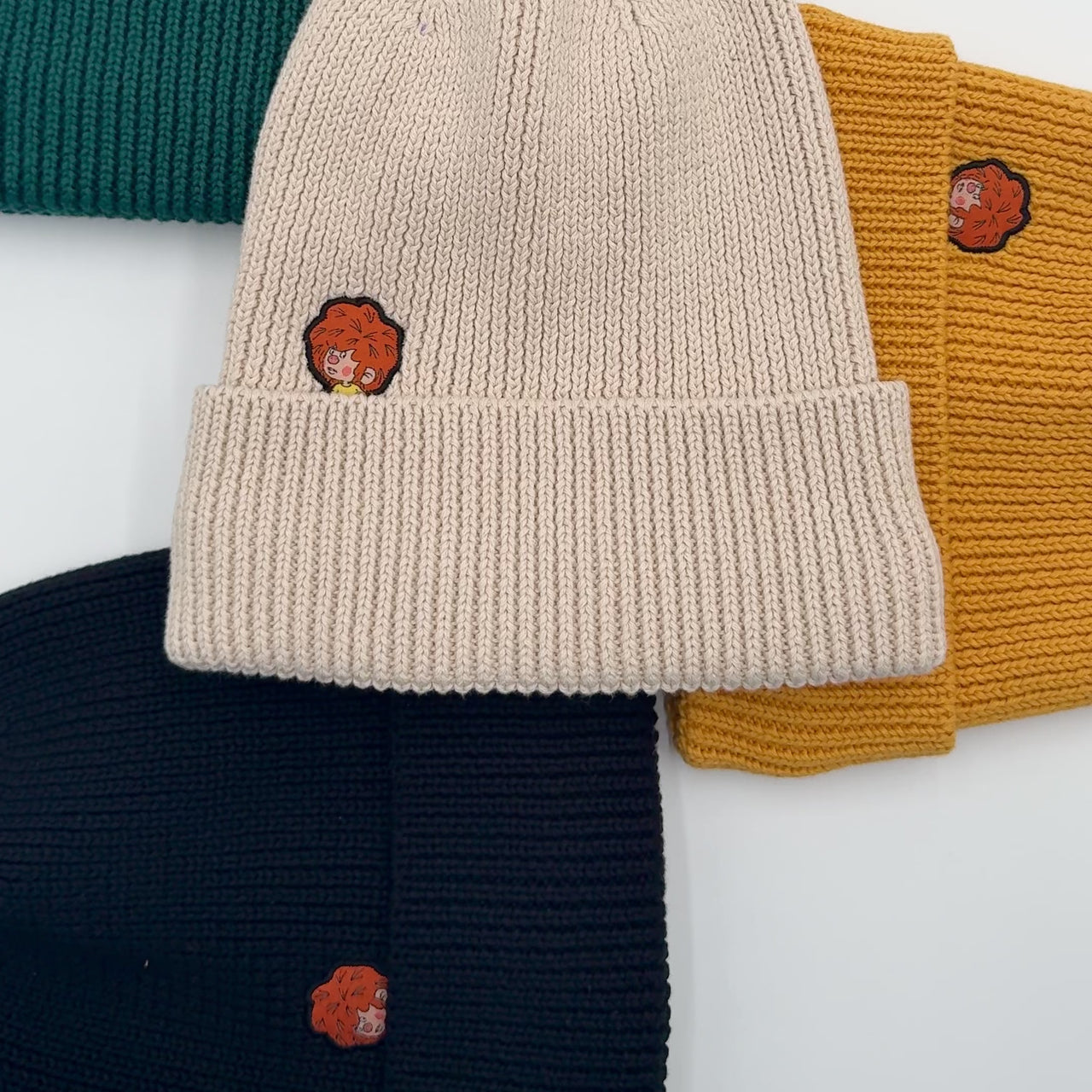 Video der Pumuckl Beanies aus Baumwolle in Schwarz, Dunkelgrün, Beige und Ockergelb mit gewebtem Pumuckl-Label