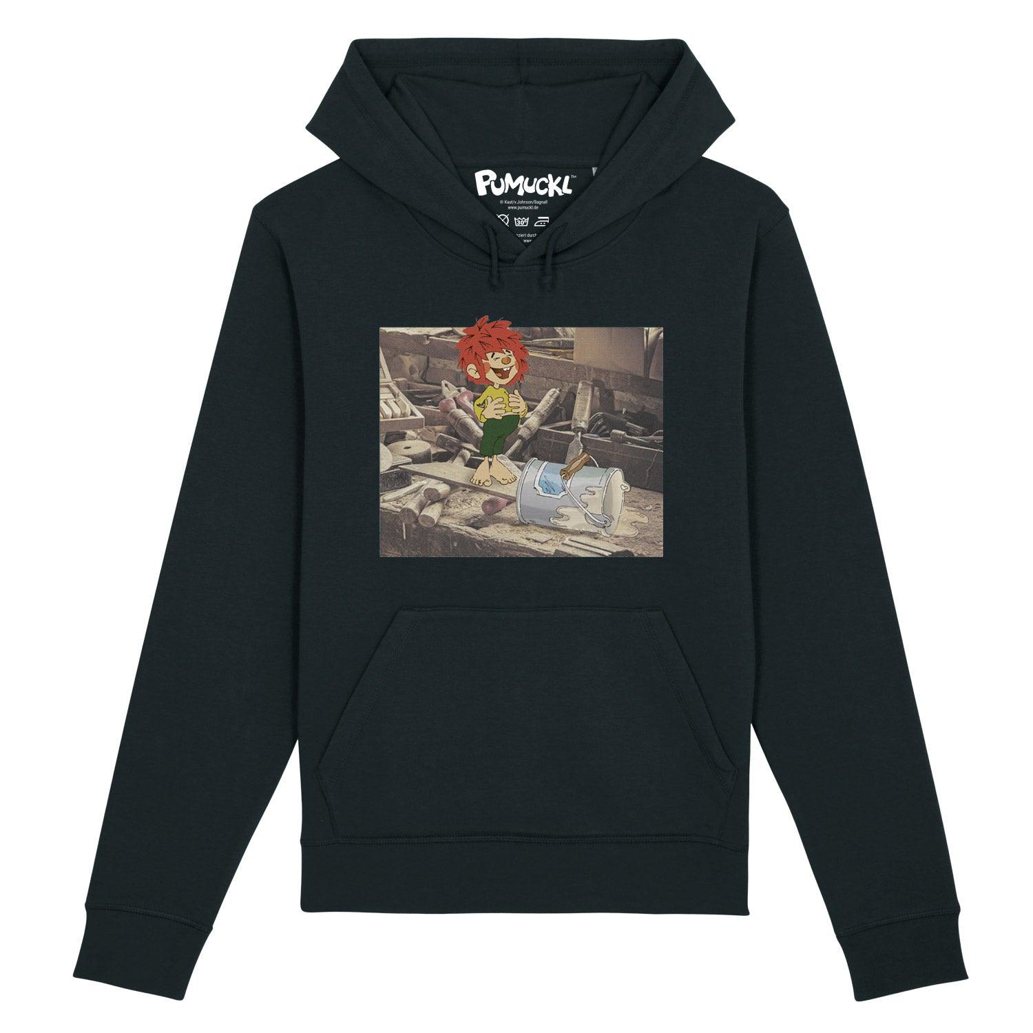 Schwarzer Pumuckl Herren Hoodie Werkstatt mit Kobold in einer unaufgeräumten Werkstatt-Szene auf dem Brustaufdruck.