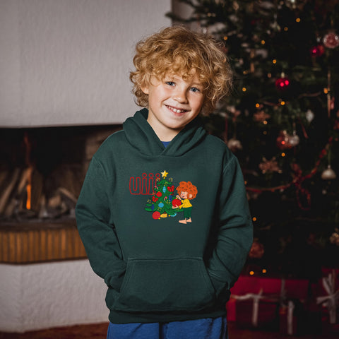 Lachender Junge im olivgrünen Pumuckl Kinder Hoodie „uiii Weihnachten“ vor Kamin und Christbaum – Weihnachtspulli für Kinder