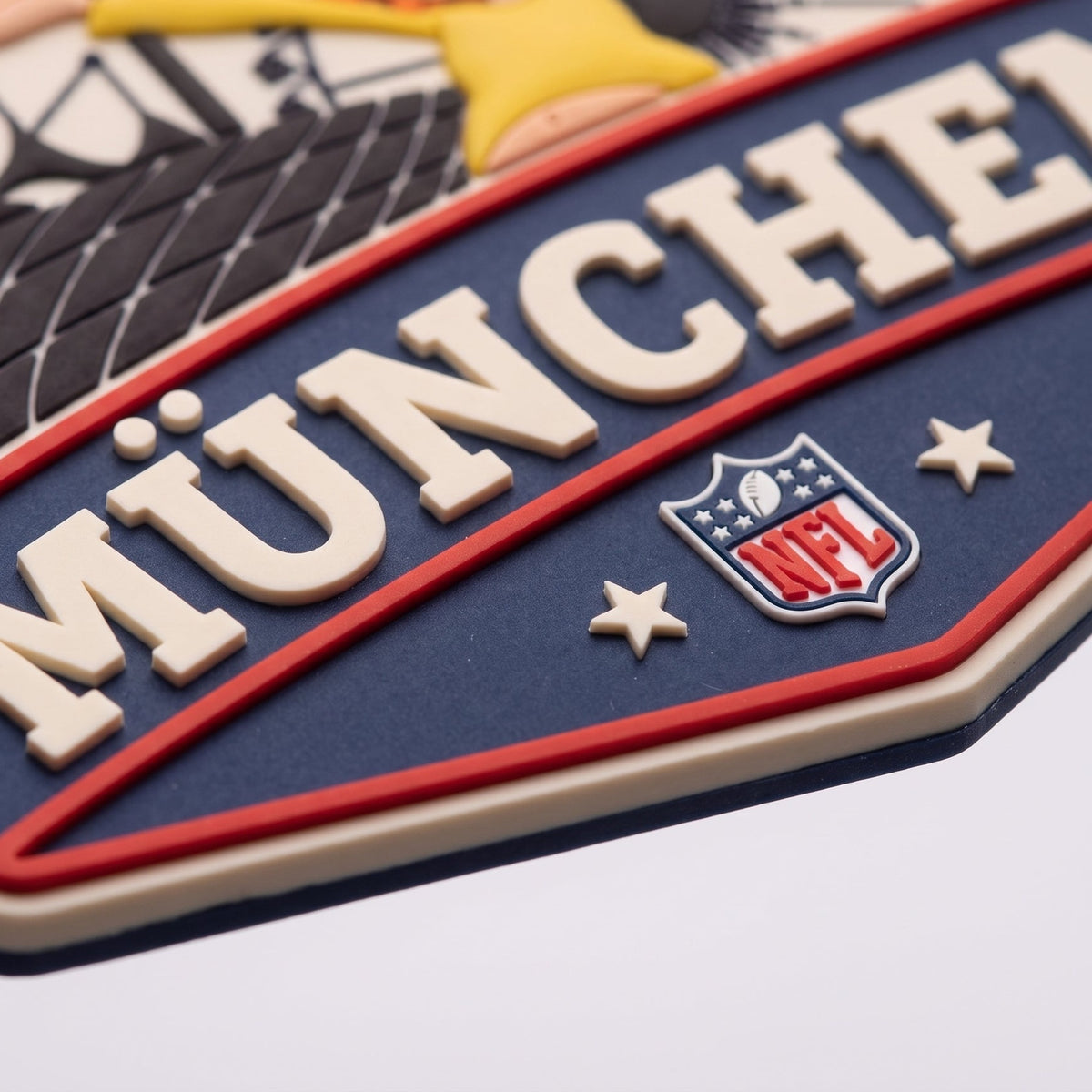 Detailaufnahme NFL x Pumuckl Magnet München – erhabener Schriftzug MÜNCHEN, NFL-Logo und mehrschichtiges 3D-Relief aus Soft-PVC