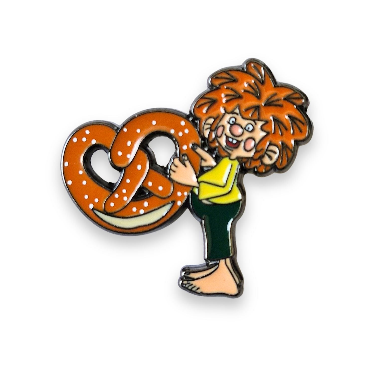 Pumuckl Pin mit rotem Haar, gelbem Hemd und grüner Hose, der eine große Brezel hält.